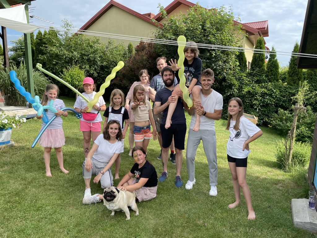 Uśmiechnięte dzieci biorące udział w zajęciach ruchowych z liną w przedszkolu.